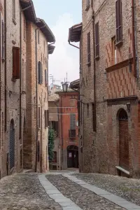 Un vicolo acciottolato in salita di Castell’Arquato, fra le case in pietra e laterizio del centro storico