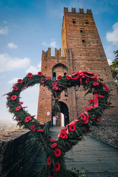 Un grande cuore di fiori rossi allestito per San Valentino davanti alla torre della Rocca Viscontea di Castell’Arquato